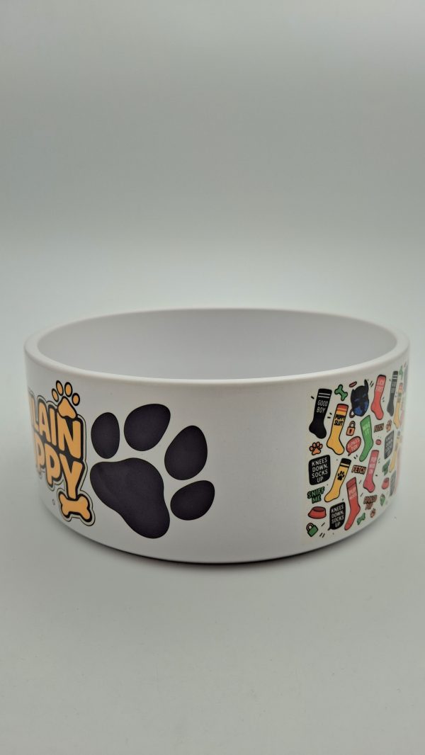 détail latéral de la gamelle en céramique VILAIN PUPPY avec une patte noire en gros planet un aperçu du motif multicolore composé d'éléments fétiches inspirés du puppy play.