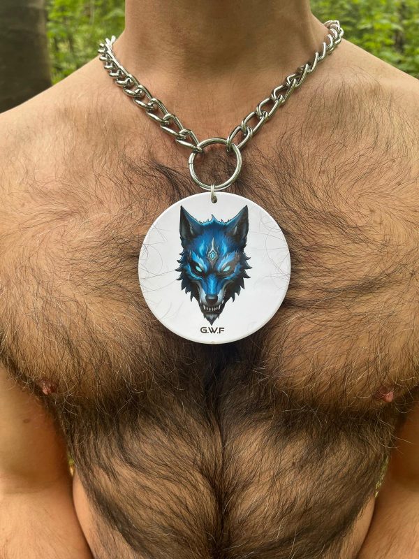 Médaillon en céramique blanche G.W.F représentant une tête de loup bleue, porté sur torse poilu en forêt.